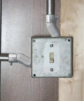 Six Piece Zinc Alloy Offset Conduit Screw Connectors For Rock Solid Electrical Box Fittings Heavy Duty Cable Adapters No Sweat Install Precision Wiring Kit installed on a wall with electrical switch.