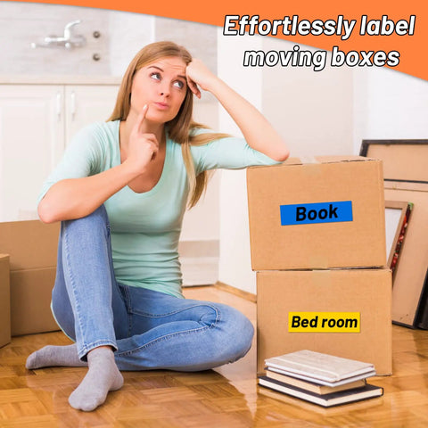 Woman labeling moving boxes with rainbow duct tape, blue 'Book' and yellow 'Bed room' tags visible, boxes in kitchen.