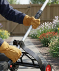 Person adjusting a Universal String Trimmer Wheel Support attaches to a Weed Eater for lawn edging in a garden setting.