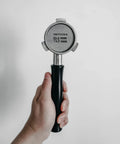 Hand holding Espresso Puck Screen For 54mm Portafilter Lower Shower Screen 53.3mm Fit 316 Stainless Steel 1.7mm Thick 150 Micron Layer