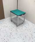 Slick Rolling Aluminum Workbench With Locking Casters set up as a packing table on a speckled floor, designed for electronics assembly.