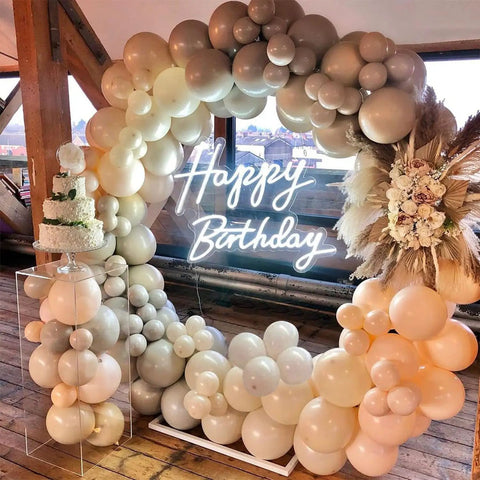 Lit Happy Birthday Neon Sign LED Light for Parties and Home Decor surrounded by balloons, cake on display