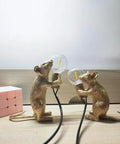 Kid Friendly Gold Finish Cute Mouse Desk Lamp With E12 LED Bulb Included, two mini resin mice lamps on a wooden desk