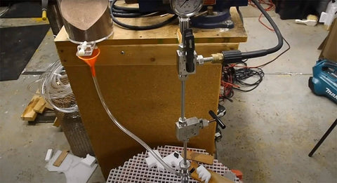 DIY waterjet cutting head assembly with mixing chamber, nozzle body, and collet on vertical stand with pressure gauge