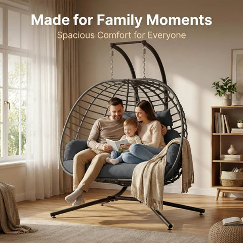 Two Person Outdoor Double Egg Swing Chair With Stand For Patio Or Garden Weather Resistant Hanging Hammock With Cushions Durable And Sturdy Dark Grey Ideal For Cozy Sunset Lounging with a family sitting indoors.