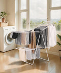 Heavy Duty Two Tier Clothes Drying Rack With 31 Sturdy Rods And Sock Clips Foldable Metal Laundry Stand Adjustable Height For Indoors Or Yard No Sweat Dry Setup with wet clothes in a bright room.