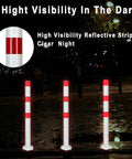 Heavy Duty 32 Inch Stainless Steel Safety Bollards With Bright Reflective Tape Removable Parking Posts For Driveways And Sidewalks Includes Six Concrete Anchors Rock Solid 2 Pack displayed at night for visibility.