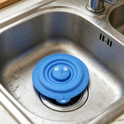 Drain Unclogger Flexible Bath Drain Cover Sealing Stopper in blue silicone placed in kitchen sink to seal drain.