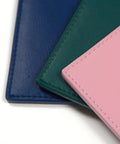 Close-up of Spruce Green Faux Leather Lab Coat Pocket Protector Tool Holder for scientists overlapped by pink and blue fabric pieces