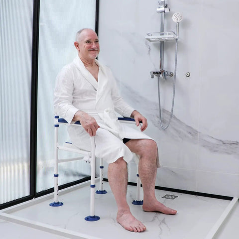 Man sitting on a Bariatric Shower Chair Heavy Duty Foldable Bath Bench With Extra Wide Seat And Private Washing Cutout 350 Lb Weight Capacity Non Slip Legs Ideal For Seniors Elderly Disabled And Pregnancy Bathing in a modern shower.