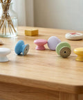 Six Pack Round Wooden Cabinet Knobs In Crisp White With Trimmable Screws For Zero Fuss Dresser And Closet Swaps featuring colorful mushroom shapes.