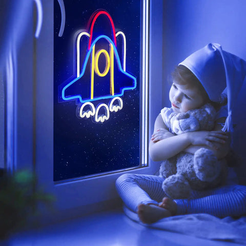 Child gazing at Rad Neon Rocket Sign LED Light For Bedroom Decor, Space Ship Theme Wall Lamp glowing in window