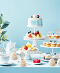 Adventure Awaits Hot Air Balloon Cupcake Toppers 36 Piece Set displayed on cupcakes with blue cloud accents on a party table.