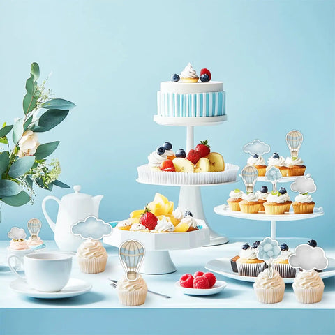 Adventure Awaits Hot Air Balloon Cupcake Toppers 36 Piece Set displayed on cupcakes with blue cloud accents on a party table.