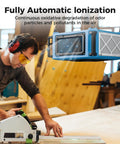 Workshop scene with Heavy Duty Hanging Dust Filtration System with 270 Degree Intake, 780 and 1080 CFM, ionizer visible above worker.