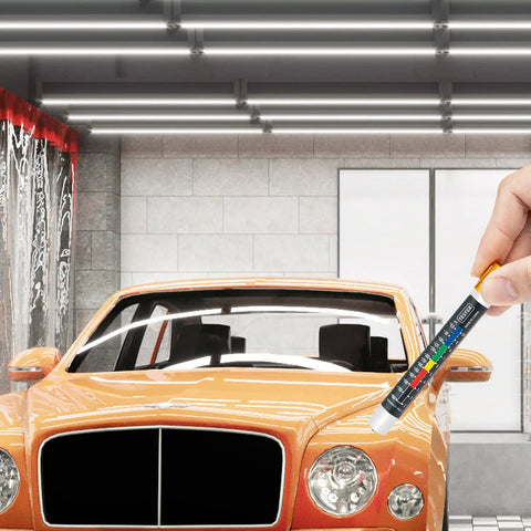 Hand using Paint Thickness Tester Meter Gauge For Cars in front of orange car in garage, Magnetic Coating Tester No Batteries Needed