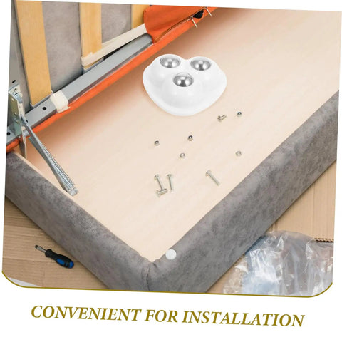 Eight Piece Stainless Steel Self Adhesive Caster Wheels With Smooth Ball Bearings For Effortless Furniture Relocation And Heavy Duty Storage Box Glide Conversion Today installed under a sofa for easy furniture movement.