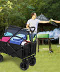 Foldable Wagon Cart With Big All Terrain Wheels And Drink Holders For Beach Camping Fishing Gardening Sports And Shopping Heavy Duty Frame Carries Up To 330 Pounds loaded with supplies at an outdoor event