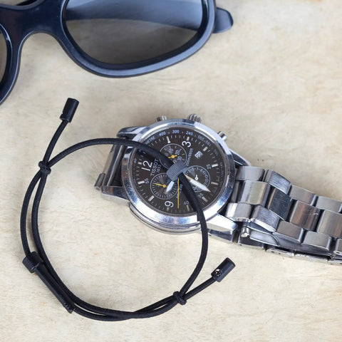 Escape Bracelet With Handcuff Key And Car Window Breaker, wristband car safety tool with sunglasses and watch on table