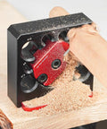 Heavy Duty Aluminum Adjustable Drill Dowel Jig With Carbide Cutter Bit For Sweet Round Profiles And Zero Hassle Woodshop Projects Quick Turn Knobs Covering Eight Through Twenty Millimeters in use showing wood shavings and red cutter.