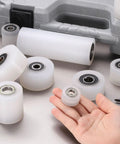 4 Pack Nylon Roller Wheels With Bearings For CNC Guiding And Flat Belt Idler Pulleys shown with hand for size comparison