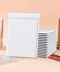 10.5x16 Inch Bubble Mailers 25 Pack Self Seal Padded Envelopes Waterproof Shipping Bags shown with books and frame