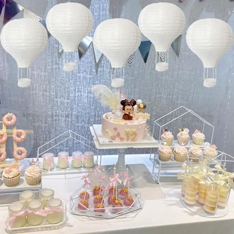 10 Pack White Hanging Hot Air Balloon Paper Lanterns 12 Inch Party DIY Decor above a dessert table at a birthday event.