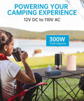 Woman using camping setup with 300W Car Power Inverter With Pure Sine Wave 60W PD USB C 2 USB A Ports And Dual 110V AC Outlets.