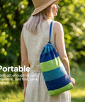 Woman carrying a striped travel bag for Ultra Comfy Cotton Hammock Portable Camping Hammock For Hanging With Tree Straps Sturdy Garden Fabric Hammock Up To 660 Lbs Includes Travel Bag Great For Camping Outdoor Indoor Patio Backyard Relaxation.