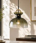 Tribesigns 11" Modern Pendant Lighting with Gradient Green Glass Shade hanging above a table, showcasing its sleek design.