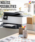 Front view of white office printer on a desk with paper; AIVA Paper Group logo top-right
