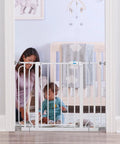 Woman securing extra wide baby safety gate for openings from 29 to 41.5 inches, 30 inches tall, in a nursery doorway