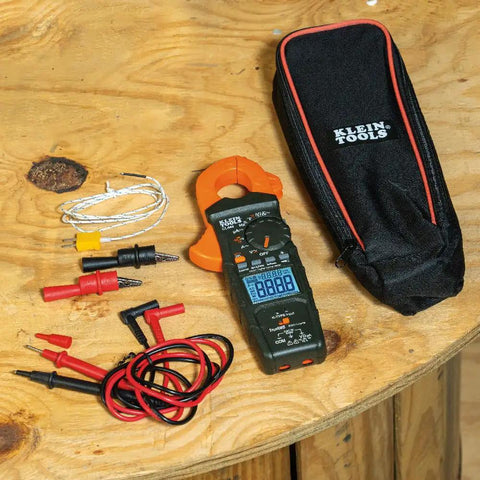 HVAC Clamp Meter All In One With Auto Ranging TRMS And NCVT Inrush And More plus accessories and carrying case on wooden table.