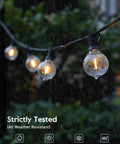 LED Outdoor String Lights 109 Ft With 52 Edison Shatterproof Bulbs Plus 2 Spares in rain, demonstrating weatherproof feature.