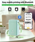 X1 Portable Bluetooth Label Printer With Tape Pre Cut And Continuous Labels Wireless Small Label Maker for Home School and Office Go To App For Quick Organization next to smartphone showing app interface on a table.