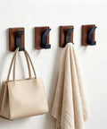 Heavy Duty Eight Piece Walnut Wood Wall Hooks Featuring Thickened Aluminum Support With Upward Non Slip Bend used for storing a handbag and towel.