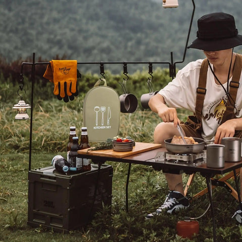 Camper using 12 Piece Outdoor Camping Cookware Set Stainless Steel Portable Kitchen Tools at campsite with scenic backdrop