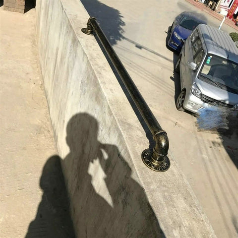 Vintage Bronze Metal Handrail Kit Indoor Outdoor Deck Railing System with shadows cast on a concrete surface.