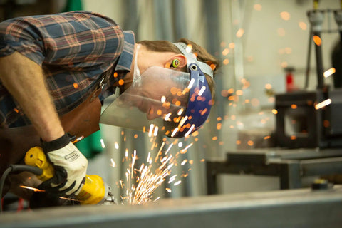 Worker wearing True Wireless Buds With Heat Activated Memory Foam Eartips For 22 dB Noise Reduction using grinder