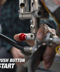 Hand pressing start button on 540-Degree 45,000 BTU Tank Top Radiant Propane Heater With Multi Directional Heat, close-up view.