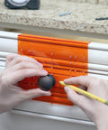 Hands using DIY Friendly No-Fuss All In One Cabinet Door And Drawer Drill Mounting Template For Precise Knob And Pull Installation