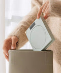 Electric Coffee Mug Warmer For Office Desk With Auto Shut Off Timer being placed in a beige container, highlighting its compact design.