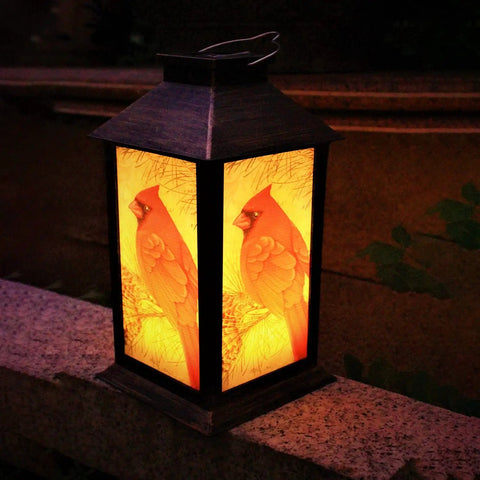 Outdoor Solar Lanterns For Hanging And Tabletop Use Waterproof LED Red Cardinal Bird Pattern Lights glowing on a patio