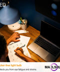 Overhead view of Tiny Reflector LED Bulbs illuminating a desk with a laptop and papers, demonstrating flicker-free lighting in use.