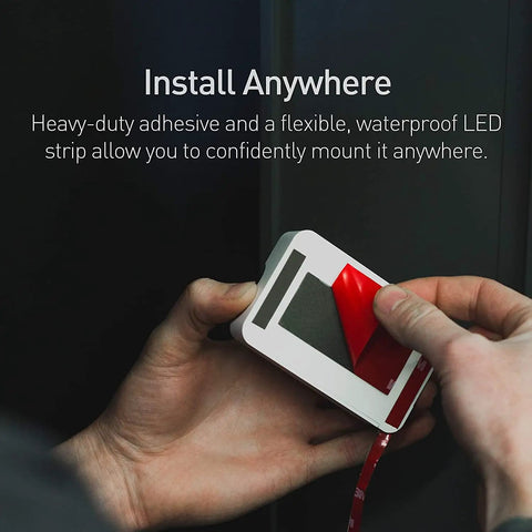 Hands applying adhesive tape to Luminoodle Under Cabinet Lighting LED Light Strip For Shelves And Kitchen Cabinets Warm White 2700K 3 Pack