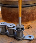 Close-up of 12 Piece Punch And Chisel Set Beefy Heavy Duty Heat Treated Metal Punches being used on a metal chain, 40Cr steel.