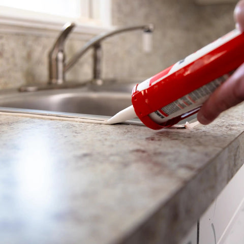 Applying Silicone Acrylic Caulk And Sealant For Kitchen Bathroom And Windows 100 Percent Waterproof Paintable With Duraguard White 5.5 Oz Easy Toolin next to sink
