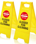 Two Pack Double Sided Closed For Cleaning Floor Signs Bright Yellow Folding Warning Plaques Heavy Duty in a commercial setting.