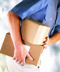Person holding two cardboard boxes sealed with Level Up Your Shipping Heavy Duty Kraft Packing Tape 3 Inches Wide By 450 Feet Long Reinforced Water Activated Gummed Roll For Cartons That Really Grips Tight Every Time.
