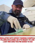 Man applying Ready Mix Epoxy Fairing Compound One Gallon Heavy Duty Formula on boat hull for smooth finish.